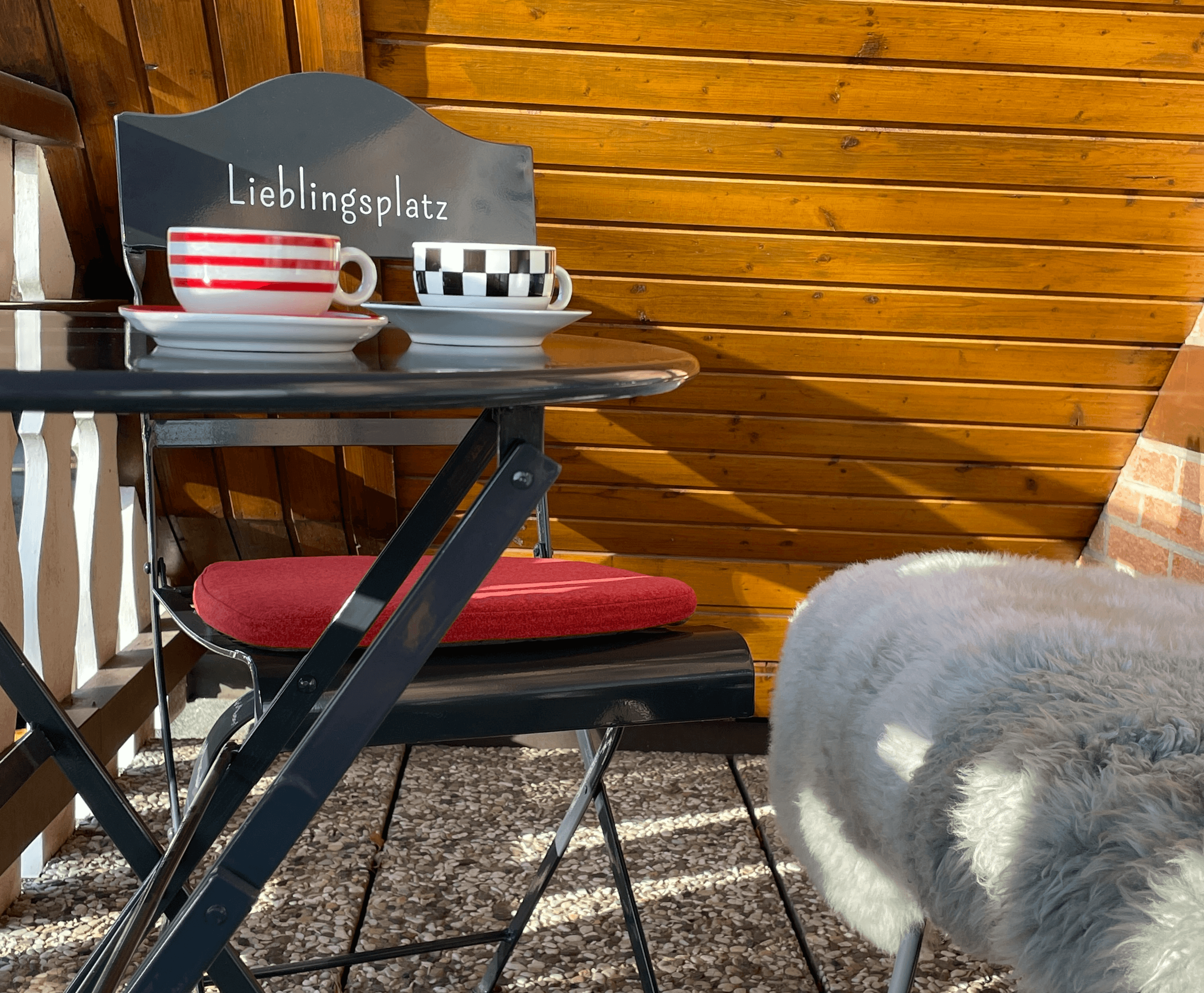 Balkon mit Tisch Bank und Stühlen