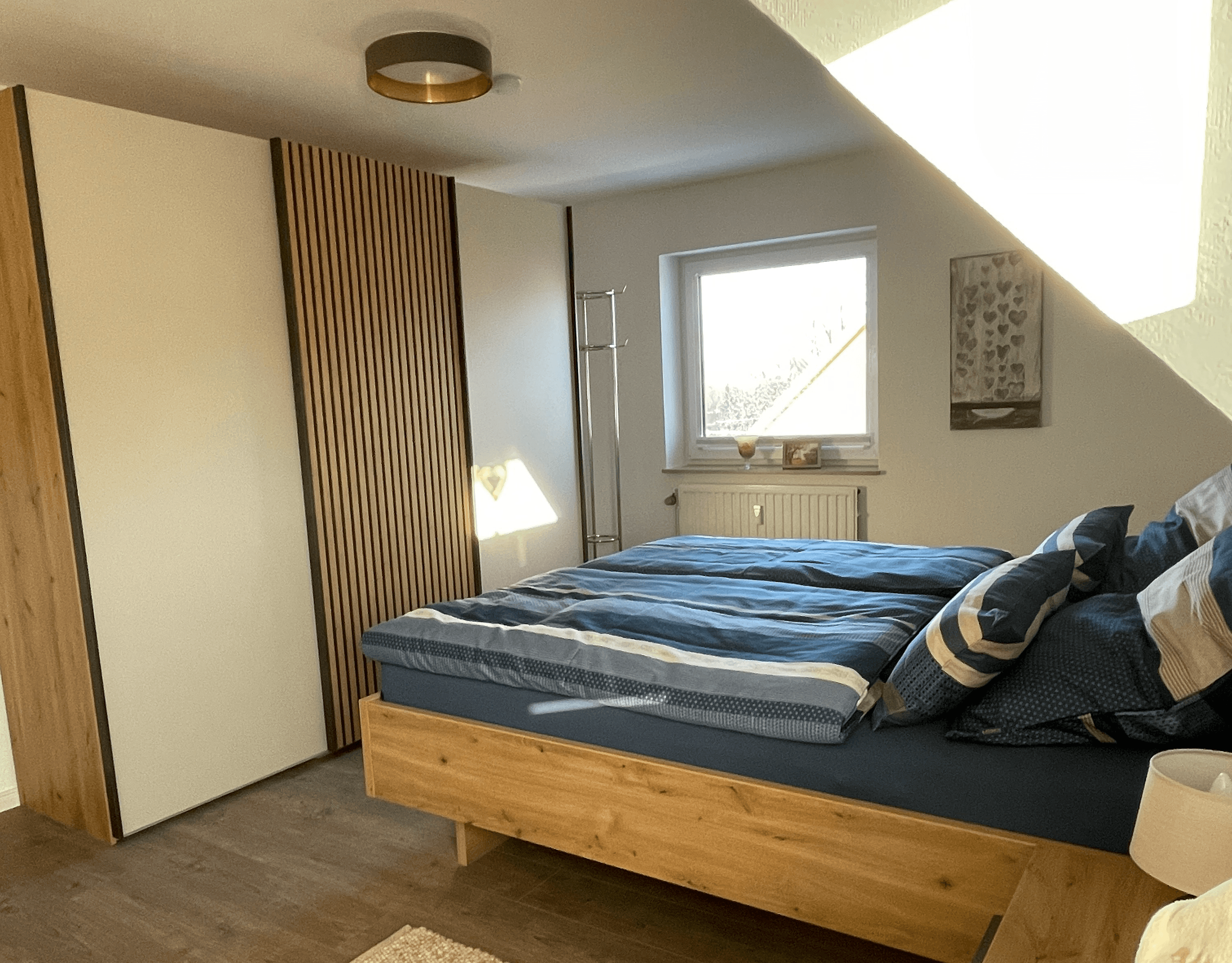 Schlafzimmer mit zwei Fenstern und Doppelbett mit Bettwäsche